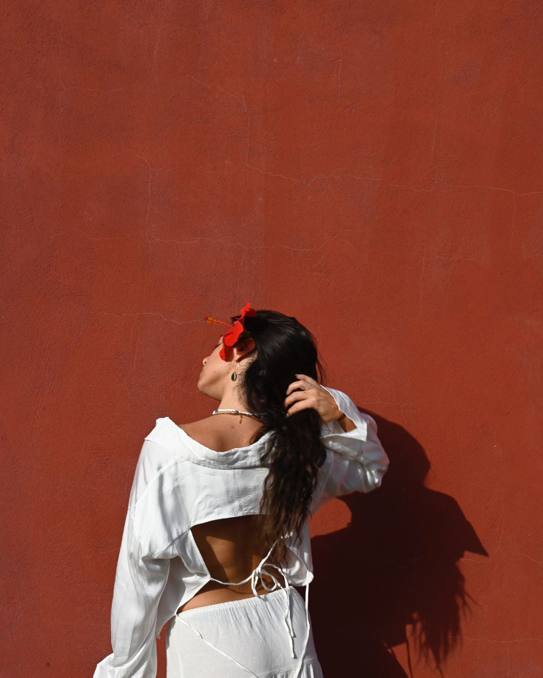 ragazza di spalle che indossa camicia bianca elegante con schiena nuda